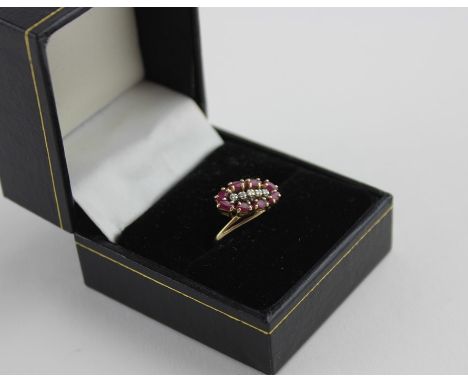 A 10ct. yellow gold, ruby and diamond dress ring, in the cross-over style, the ovoid mount set row five round cut diamonds bo