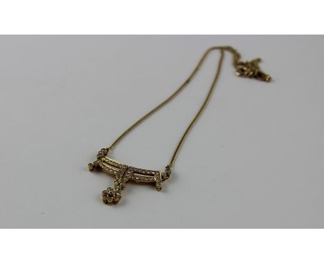 A 14ct. yellow gold and diamond pendant choker necklace,&nbsp;the pendant fashioned as two curved horizontal bars joined by v