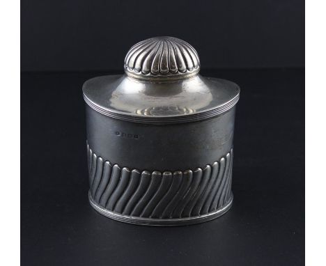 A silver oval tea caddy, by George Unite, assayed Birmingham 1911, having semi-fluted wrythen body, ribbed rim and hinged cov