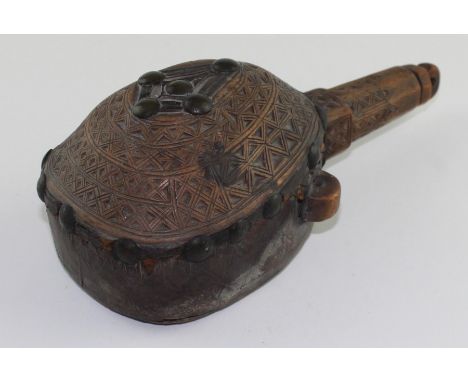 A mid-19th century North African carved wood and leather flask, domed to front carved with geometric decoration, hide covered