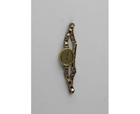 A Certina quartz 9ct. gold ladies' watch, having signed gilded oval dial with raised baton hour markers, 17.5mm wide case imp