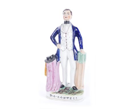 19th century Staffordshire figure of Daniel O'Connell. The moulded figure standing in a blue coat, beside a draped pedestal c