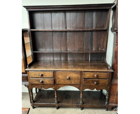 An 18th century South Wales oak dresser, the moulded cornice above two shelves and a planked back, the rectangular planked to