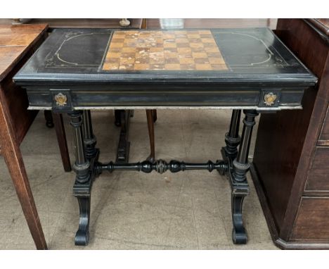 A Victorian ebonised brass inlaid games / card table, the top with chequer board, the hinged top with a green baize surface a