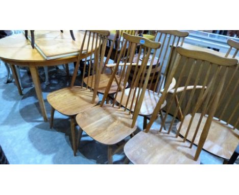 An extending kitchen table together with a set of six Ercol style stickback chairs