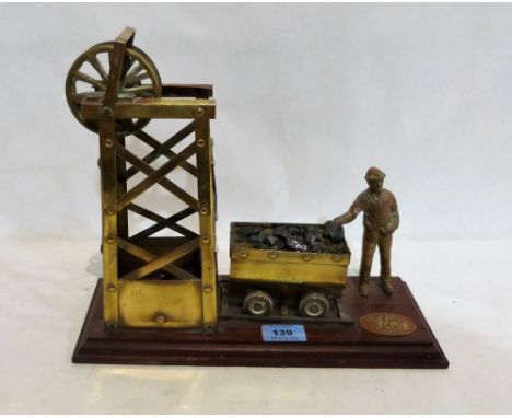 A brass model of a colliery lift engine with coal truck and miner. 13'' wide