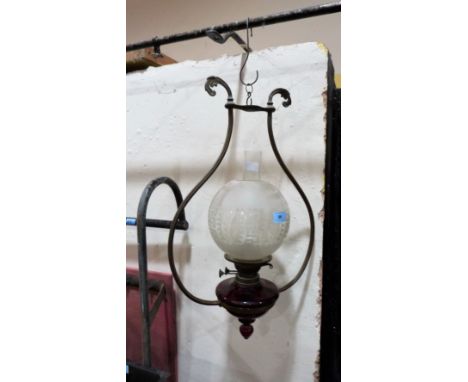 A hanging oil lamp with ruby glass fount and acid etched shade