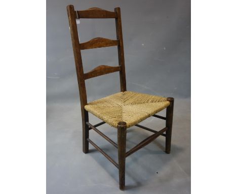 A late 19th / early 20th century ladder back chair, with rush seats, on tapered legs 