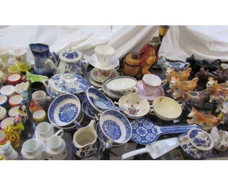 A moulded porcelain part tea set together with cow creamers, tea cups and saucers, blue and white pottery, egg cups, golfing 