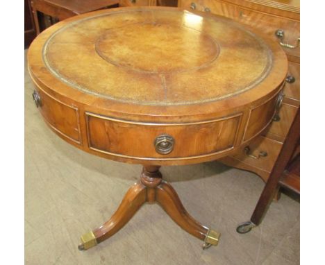 A 20th century yew wood reproduction drum table with circular leather inset top on a tripod, 65cm diameter