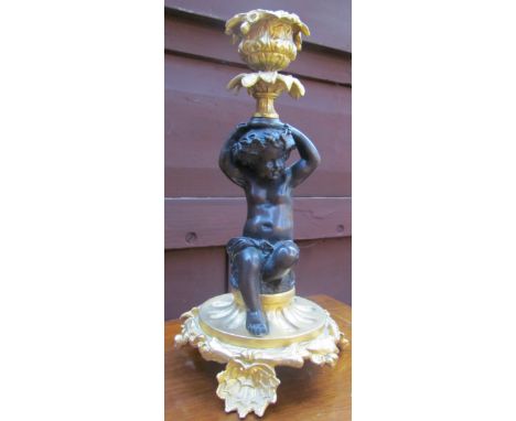A gilt metal cherub candlestick