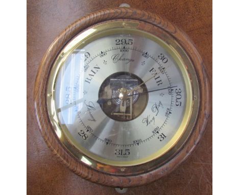 An oak cased aneroid barometer of circular form