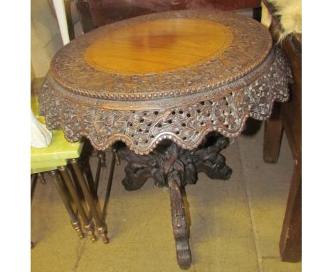A Burmese carved hardwood occasional table on a carved tripod base 