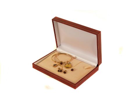 A collection of garnet set jewellery,  including a 9ct gold hinged bangle, cabochon garnet ear studs, a tear drop pendant on 
