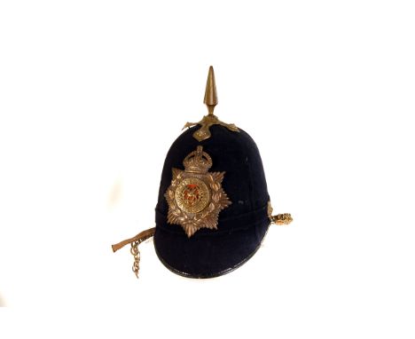 A pre-WWI South Wales Borderers helmet, the blue cloth backed helmet with brass spike to top, with the Borderers badge to fro