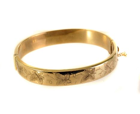 A 9ct gold bangle, one half with engraved leaf designs, hallmarked, approx 14.8g
