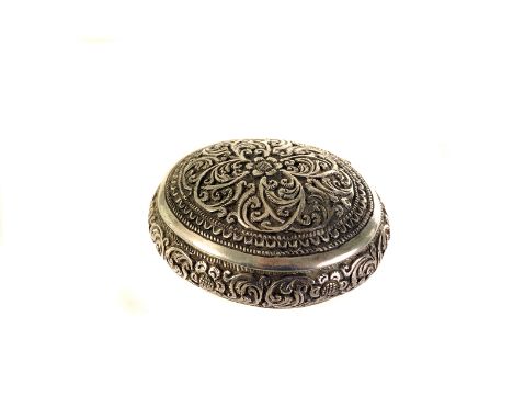 An interesting Middle Eastern white metal pill or snuff box, the oval domed form with hinged lid decorated with ornate raised