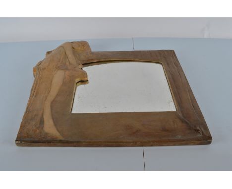 An Art Nouveau wall mirror, in the style of Goldscheider. The shaped rectangular plate enclosed by frame cast with diaphanous