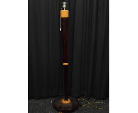 An Art Deco stained and bleached wood standard lamp, of tapered slender form on circular base on three ball feet. 150cm max h