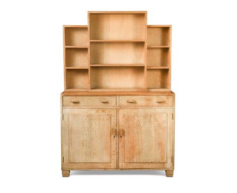 A Heal's limed oak bookcase or dresser, circa 1930, the stepped top section with open shelves above a pair of drawers and cup