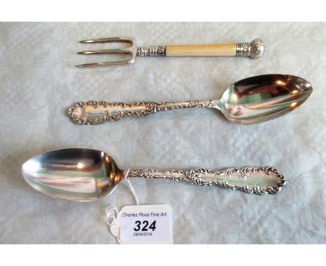 A pair of early 20th century American sterling silver serving spoons, with cast scrolling edges, together with an ivory handl