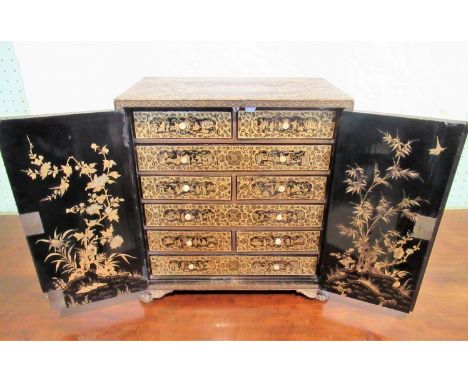 A 20th century Chinese black lacquer painted and gilt chinoiserie decorated table cabinet, the top decorated with figures and