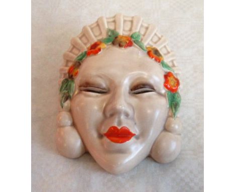A 1930's Clarice Cliff wall pocket, modelled as an Asian lady wearing headdress and floral garland, printed marks, 18 x 13cm.