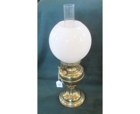 An Edwardian brass paraffin lamp with spherical opaque shade.