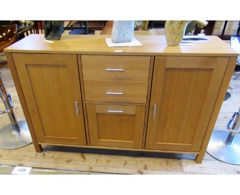 A contemporary beech veneered sideboard, the rectangular top over two central drawers and cupboard flanked by further cupboar