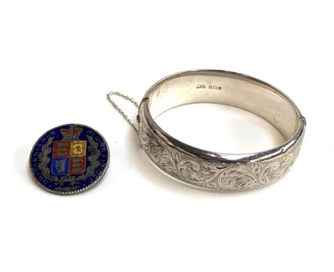 A silver bangle with engraved foliate design, hallmarked for Walker &amp; Hall, Birmingham, 1958 28g; together with an enamel