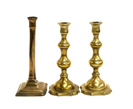 An 18th century brass reeded candlestick, on square base, 26cm high; together with a later pair 