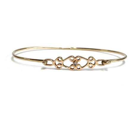 A 9ct gold bangle with Celtic style design, set with a small central diamond, 4.2g 