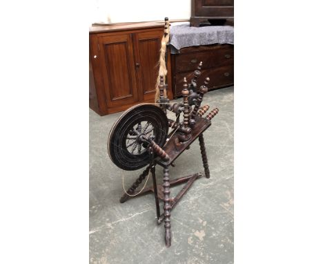 A dark oak bobbin turned oak spinning wheel, approx. 85cm long 