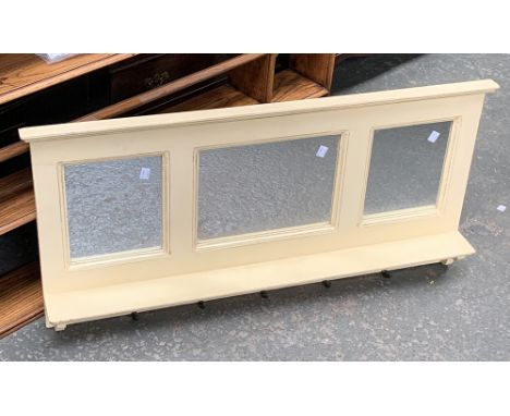 A cream painted three part mirror, with shelf and coat hooks, 98cmW 