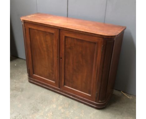 A mahogany and crossbanded cabinet, fielded panel doors opening to a single adjustable shelf, flanked by reeded rounder corne