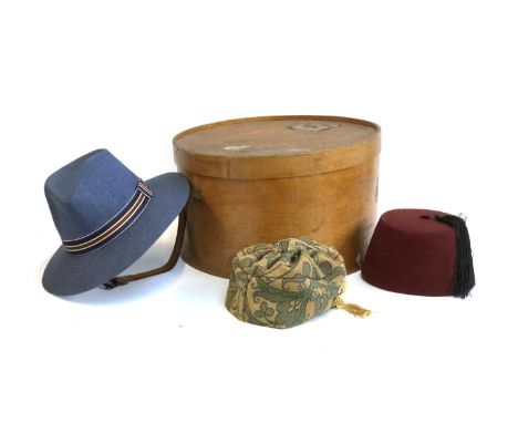 A Samson Riga vintage wooden hat box with travel stickers for Southern Railway, containing a Failsworth navy straw hat; a fez