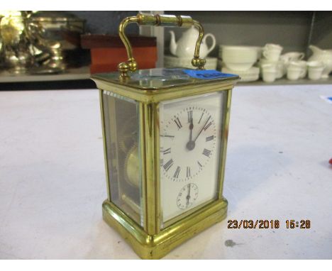 A small brass mantel clock with a bell 