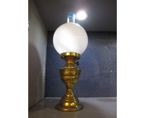 A brass oil lamp with a glass shade 