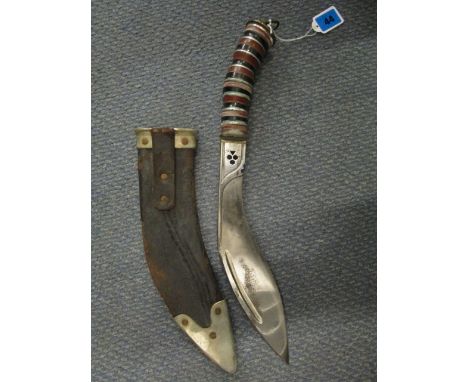 An early 20th century Kukri with a coloured banded handle and leather metal mounted scabbard 