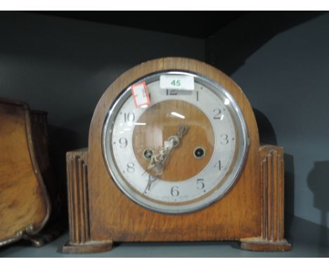 An oak bodied mantle clock with chime and art deco design