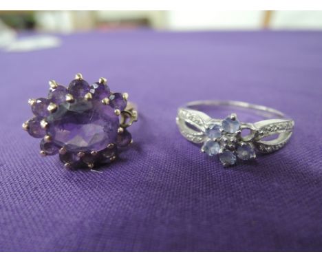 Two ladies dress rings including an amethyst style oval cluster on a raised claw set basket mount on a 9ct gold loop and a ta