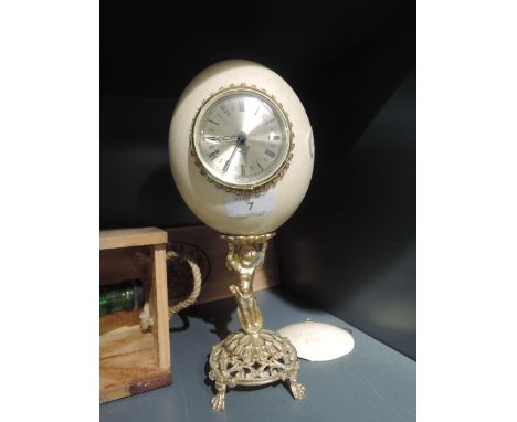 An Ostrich egg mantle clock with brass style cherub design bass