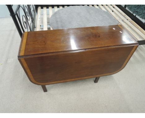 A 19th century mahogany drop leaf dining table having crossband chevron inlay decoration on square gate legs 