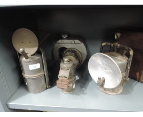 A selection of vintage motor car and cycle lights and lamps including Carbide and Lucas