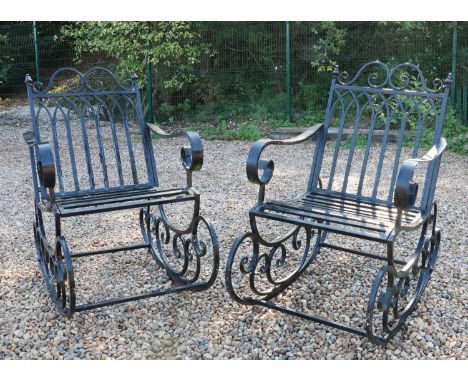 A pair of wrought iron garden rocking chairs,with Gothic arched backs,58.5cm wide100cm deep94cm high, seat 42cmCondition Repo