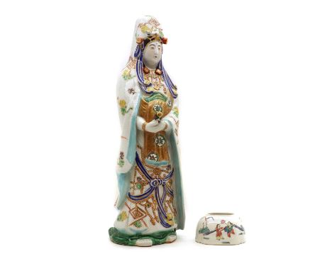 A Japanese porcelain figure of Kwannon,20th century, wearing a long ornate robe, holding a scroll in his hands, 48cm high, an