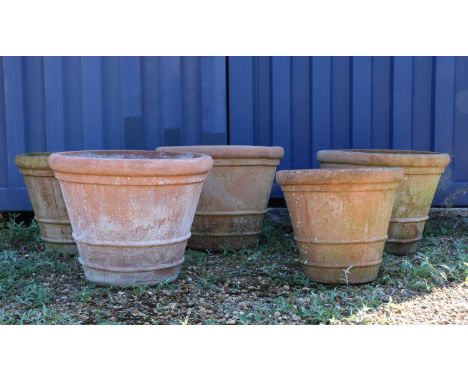A set of four Italian terracotta garden terrace urnseach with a reeded band,71cm diameter57cm high,together with a smaller ex