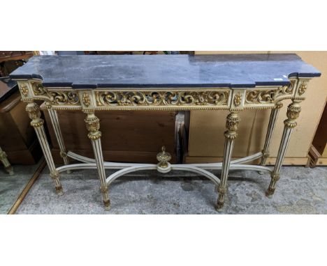 A painted and giltwood console table with black marble top, pierced floral scrolled decoration, on leaf carved turned and flu