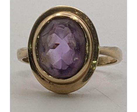 A 9ct gold ladies ring set with a central oval cut amethyst, size R 1/2, 4.3gLocation: 