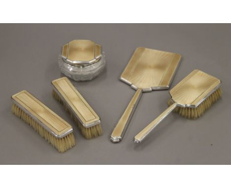 A silver and enamel dressing table set.